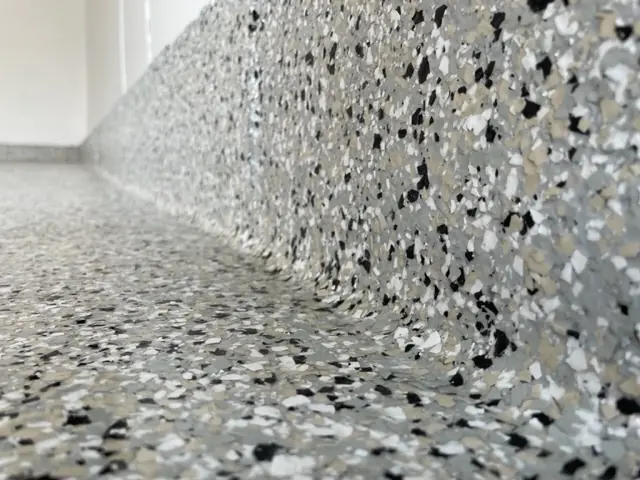 Flake finish along a garage floor and wall edge